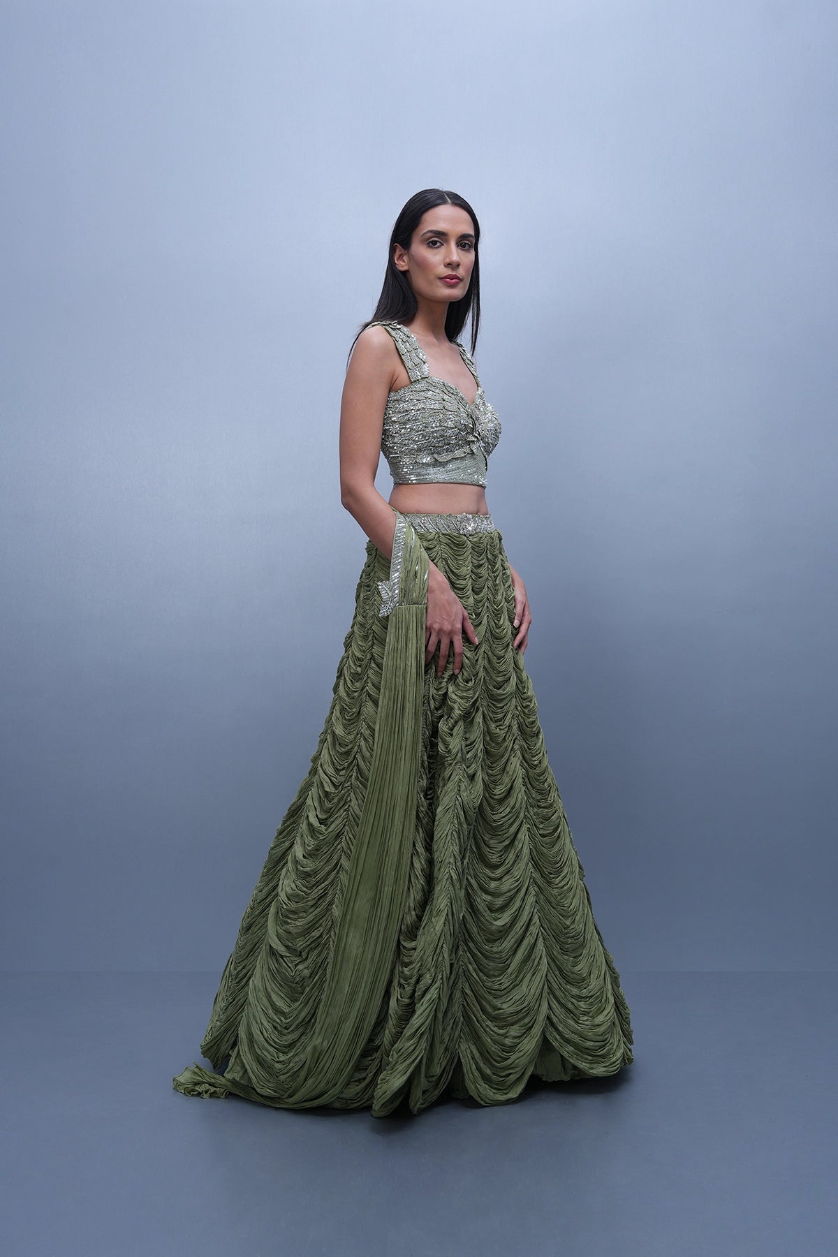 Sage green lehenga with an embellished blouse and an attached drape