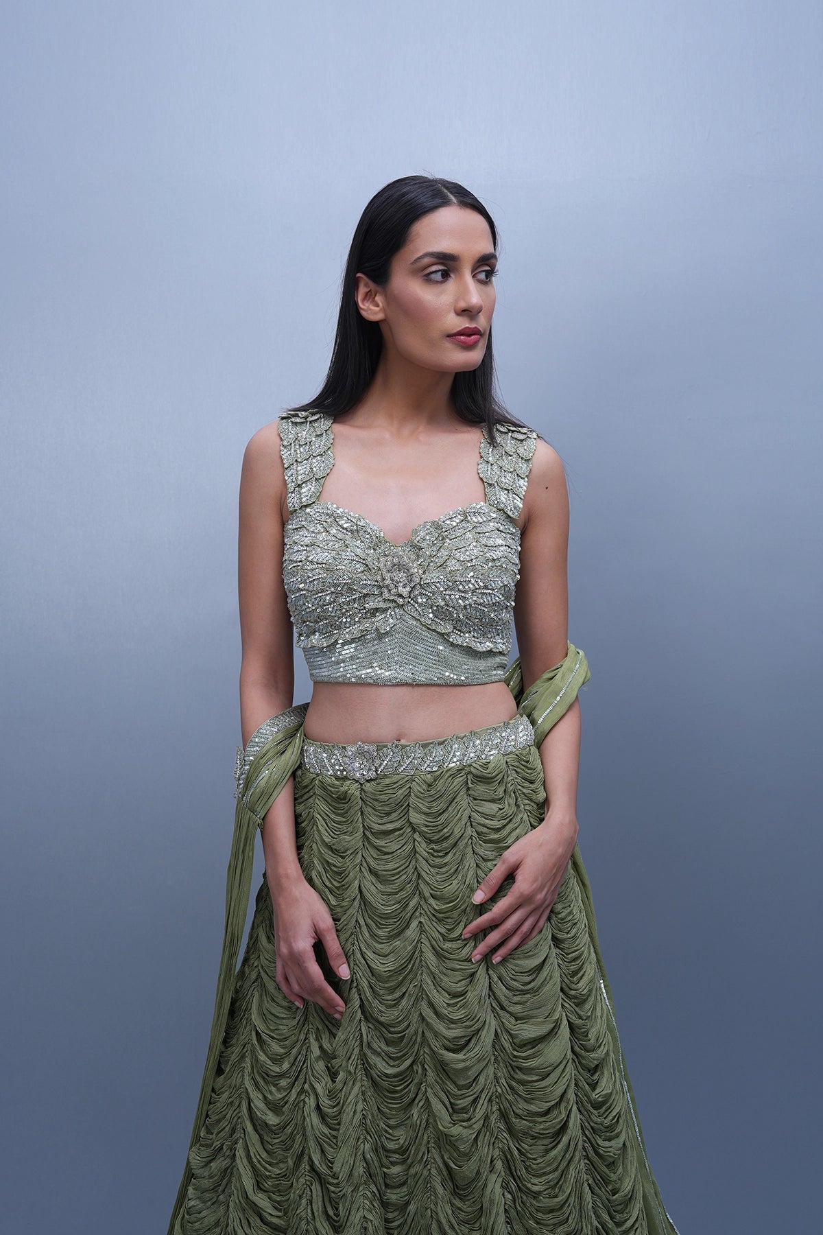 Sage green lehenga with an embellished blouse and an attached drape