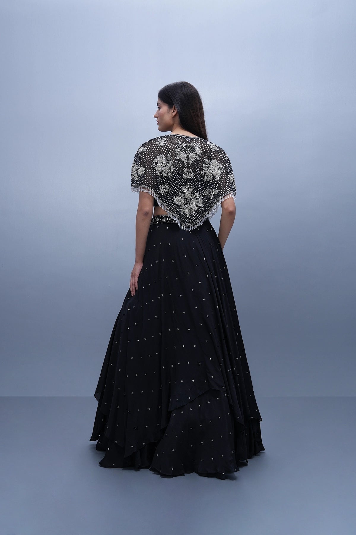 Black lehenga set in chinnon with spaghettic blouse and cape